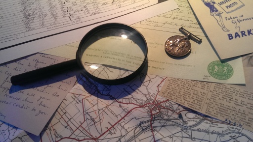 Photograph of maps, documents and a magnifying glass